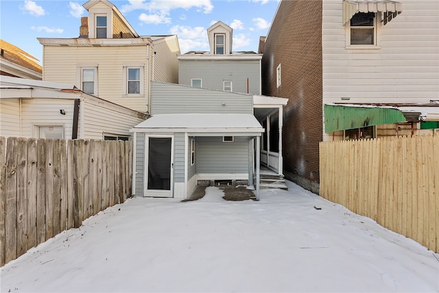 view of snow covered rear of property