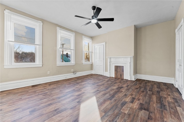 unfurnished living room featuring ceiling fan and dark hardwood / wood-style flooring