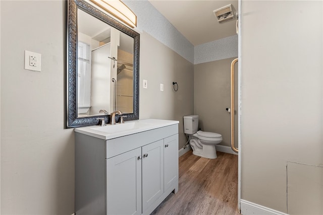 bathroom with a textured ceiling, wood-type flooring, vanity, toilet, and walk in shower