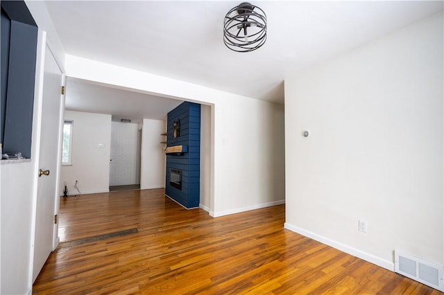 empty room with hardwood / wood-style flooring and a large fireplace