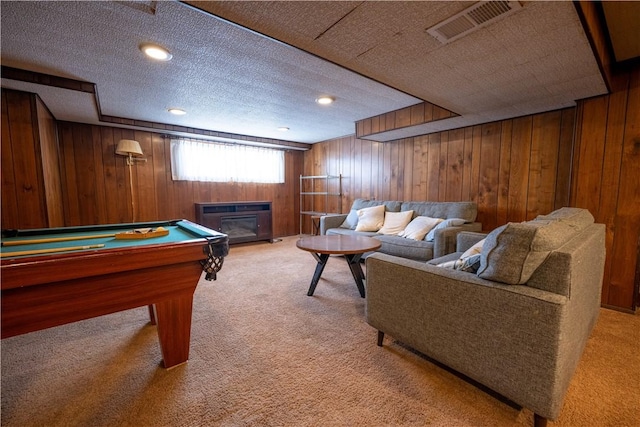 rec room featuring a textured ceiling, carpet floors, and wooden walls