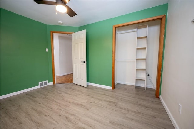 unfurnished bedroom with ceiling fan, light hardwood / wood-style flooring, and a closet