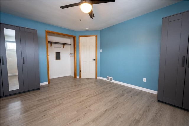 unfurnished bedroom with multiple closets, ceiling fan, and light hardwood / wood-style floors