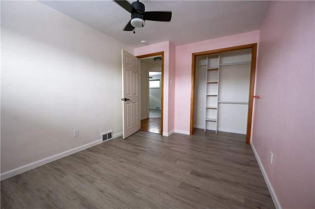 unfurnished bedroom featuring a closet, ceiling fan, and dark hardwood / wood-style flooring