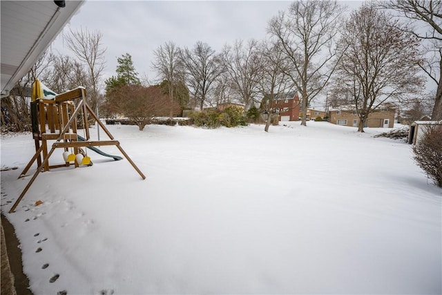 yard covered in snow with a playground