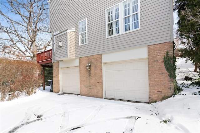 view of snowy exterior with a garage