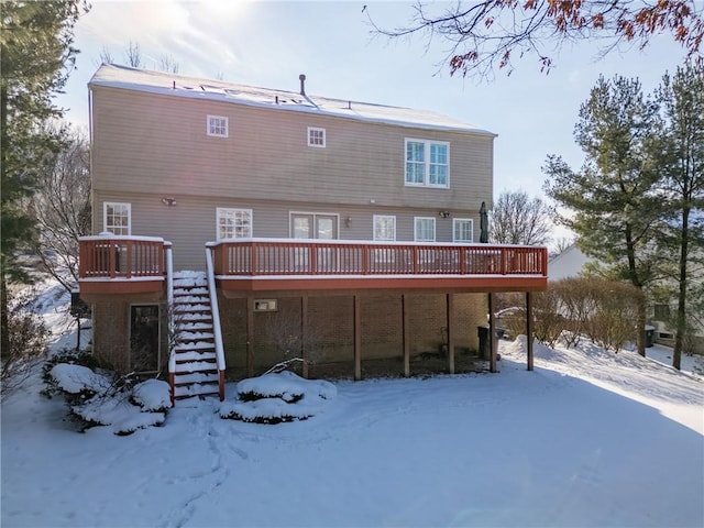 snow covered house featuring a deck