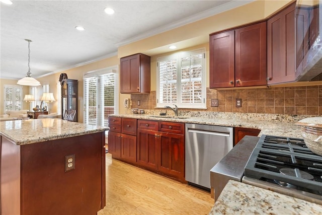 kitchen with pendant lighting, a center island, stainless steel appliances, decorative backsplash, and sink