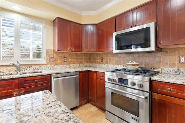 kitchen featuring sink, light stone countertops, light hardwood / wood-style flooring, and appliances with stainless steel finishes