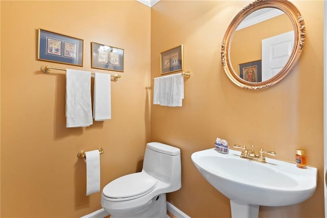 bathroom with crown molding, sink, and toilet