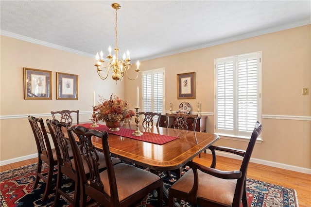 dining area with plenty of natural light, hardwood / wood-style floors, crown molding, and a chandelier