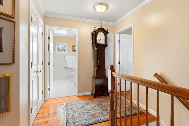 corridor with light wood-type flooring and ornamental molding