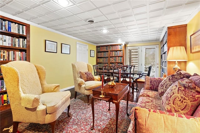 living area with built in features and ornamental molding