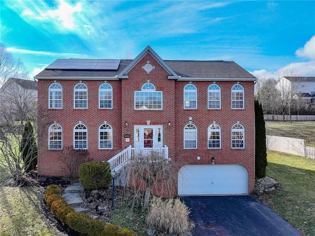 view of front of property featuring a garage and solar panels