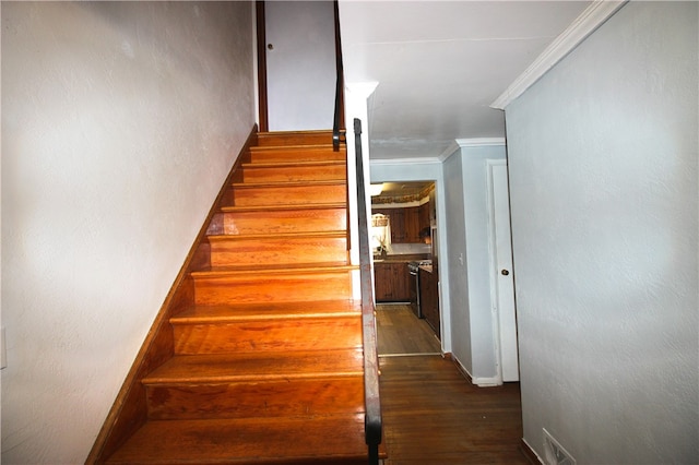 staircase featuring ornamental molding and hardwood / wood-style floors