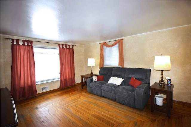 living room featuring plenty of natural light and parquet flooring