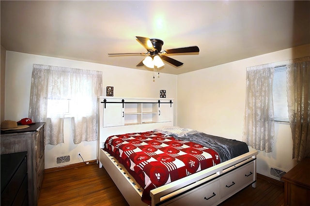 bedroom with ceiling fan and dark wood-type flooring