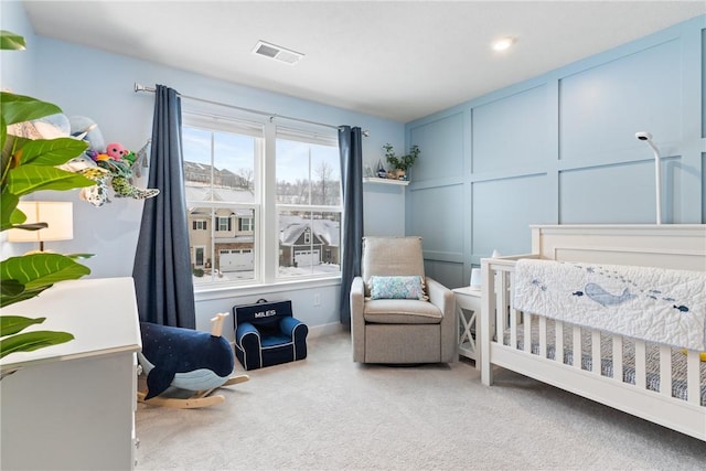 bedroom featuring carpet and a nursery area