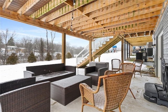 snow covered patio featuring an outdoor living space