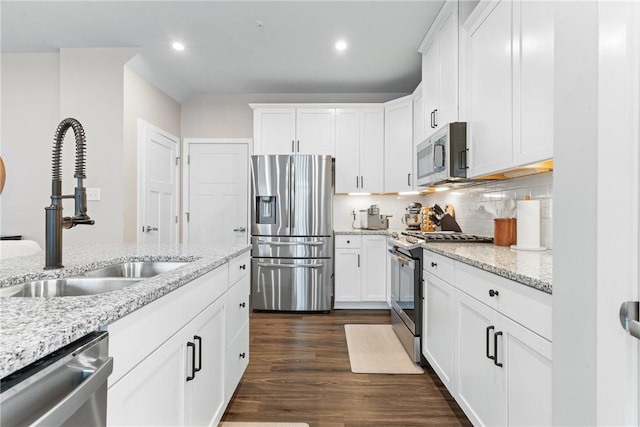 kitchen with white cabinets, stainless steel appliances, tasteful backsplash, and sink