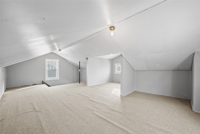 bonus room featuring light carpet and vaulted ceiling