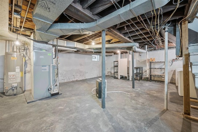 basement with water heater, heating unit, and washer / dryer