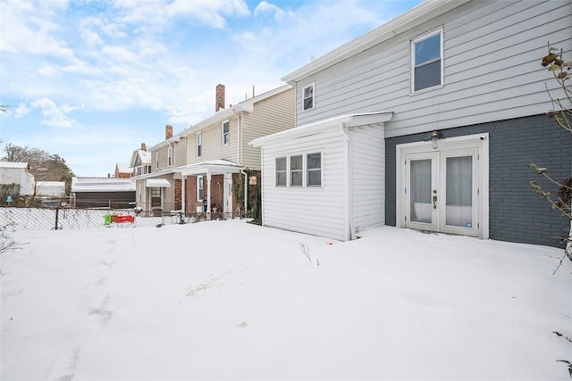 snow covered property featuring french doors