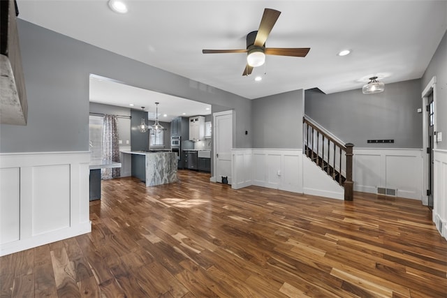 unfurnished living room featuring dark hardwood / wood-style floors and ceiling fan