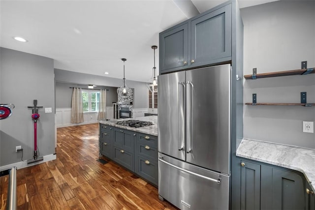 kitchen featuring light stone countertops, decorative light fixtures, dark hardwood / wood-style floors, and appliances with stainless steel finishes