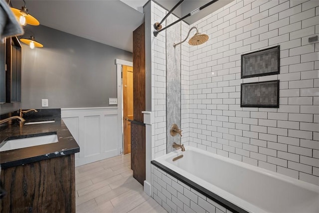 bathroom with tiled shower / bath and vanity