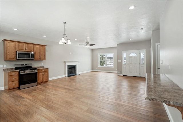 kitchen with ceiling fan with notable chandelier, light hardwood / wood-style flooring, and stainless steel appliances