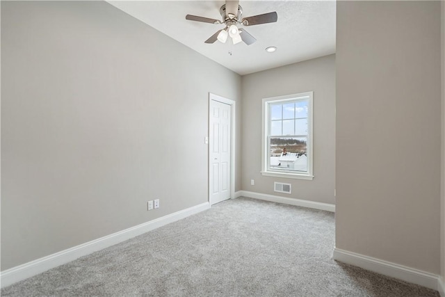 carpeted empty room featuring ceiling fan