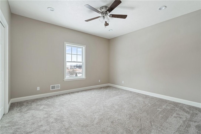 spare room with ceiling fan and light colored carpet