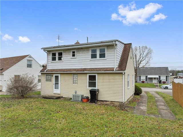 rear view of property with a lawn and central AC