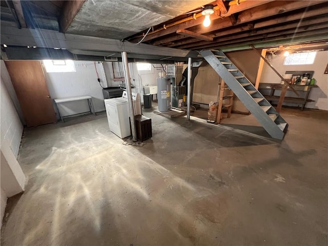 basement featuring washer and clothes dryer, sink, and electric water heater