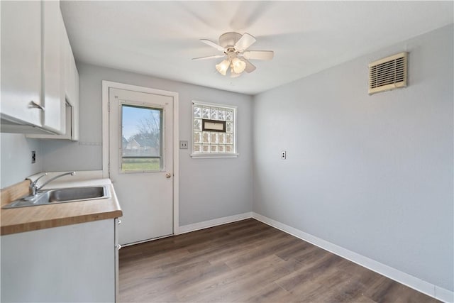 washroom featuring sink, ceiling fan, dark hardwood / wood-style floors, and cabinets