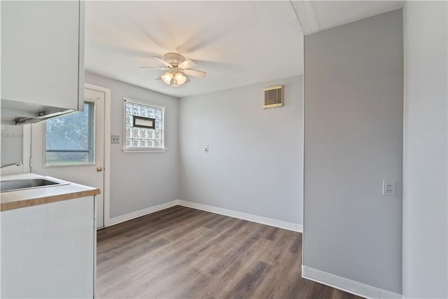 spare room featuring ceiling fan, sink, and dark hardwood / wood-style flooring