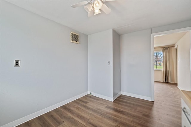 spare room with ceiling fan and dark hardwood / wood-style floors