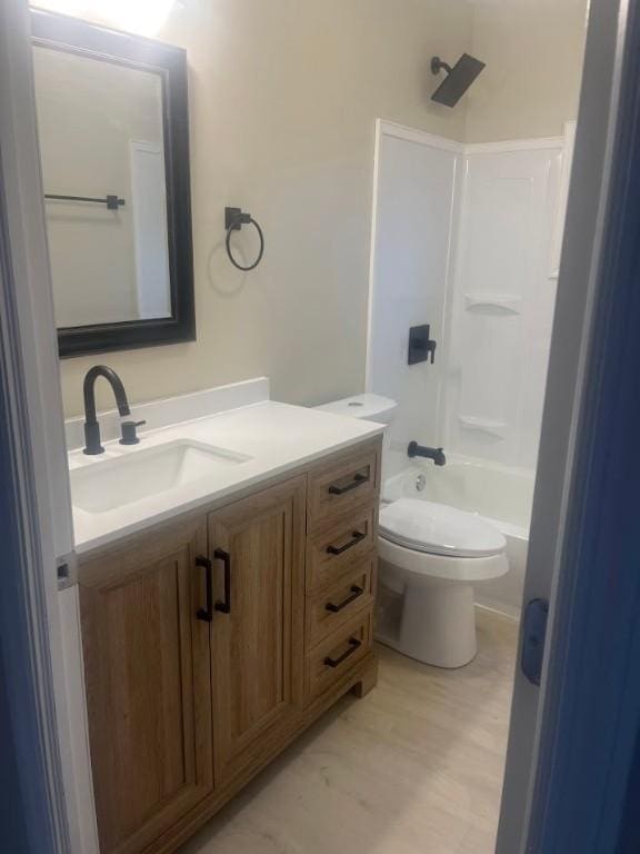 full bathroom featuring vanity, toilet, tub / shower combination, and hardwood / wood-style floors