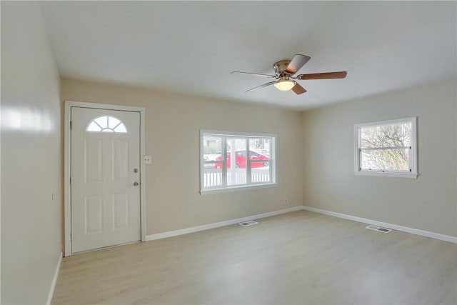 foyer entrance featuring ceiling fan, light wood-type flooring, and a wealth of natural light