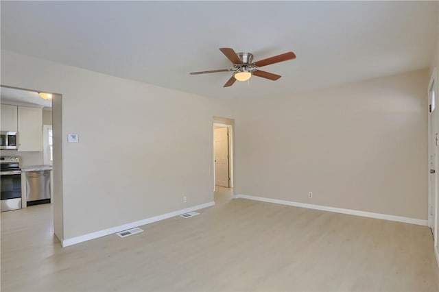 empty room with ceiling fan and light hardwood / wood-style flooring