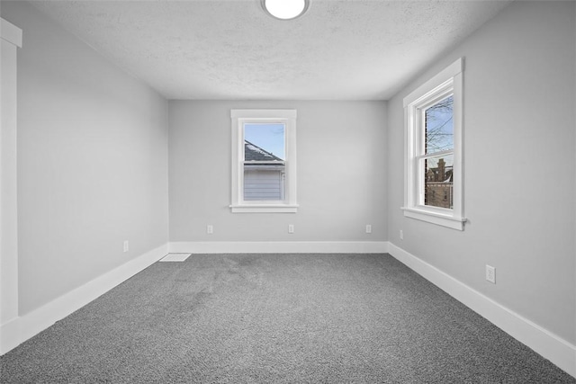 unfurnished room with a textured ceiling and carpet floors