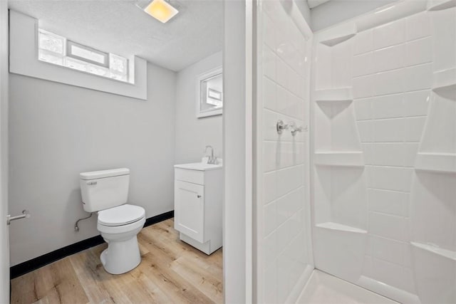 bathroom featuring vanity, toilet, walk in shower, and hardwood / wood-style floors