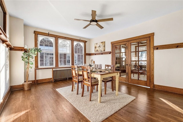 dining area featuring dark hardwood / wood-style floors, radiator, ceiling fan, and french doors