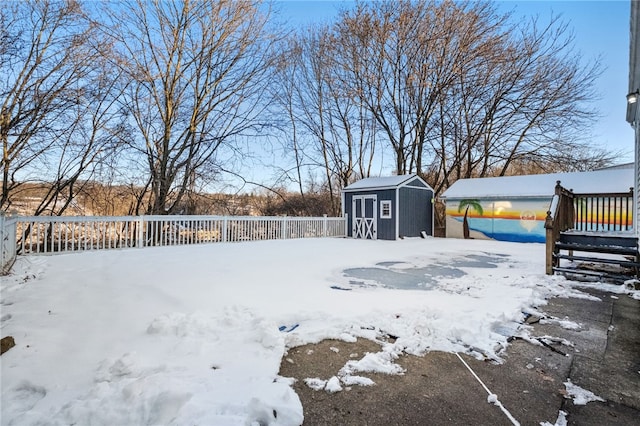 yard covered in snow featuring a storage unit