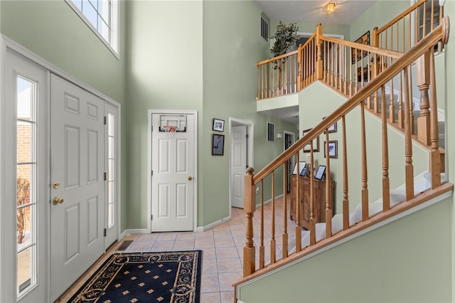 tiled foyer entrance featuring a towering ceiling