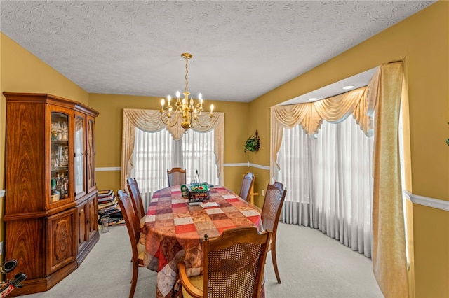 carpeted dining room with a textured ceiling and a notable chandelier