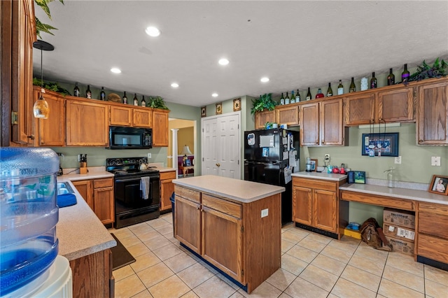 kitchen featuring black appliances, built in desk, a center island, and light tile patterned floors