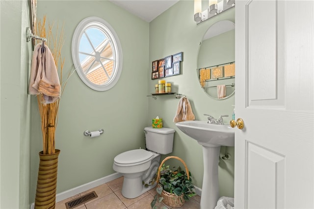 bathroom with sink, toilet, and tile patterned flooring