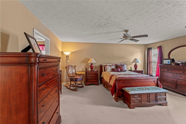 carpeted bedroom featuring ceiling fan and a textured ceiling